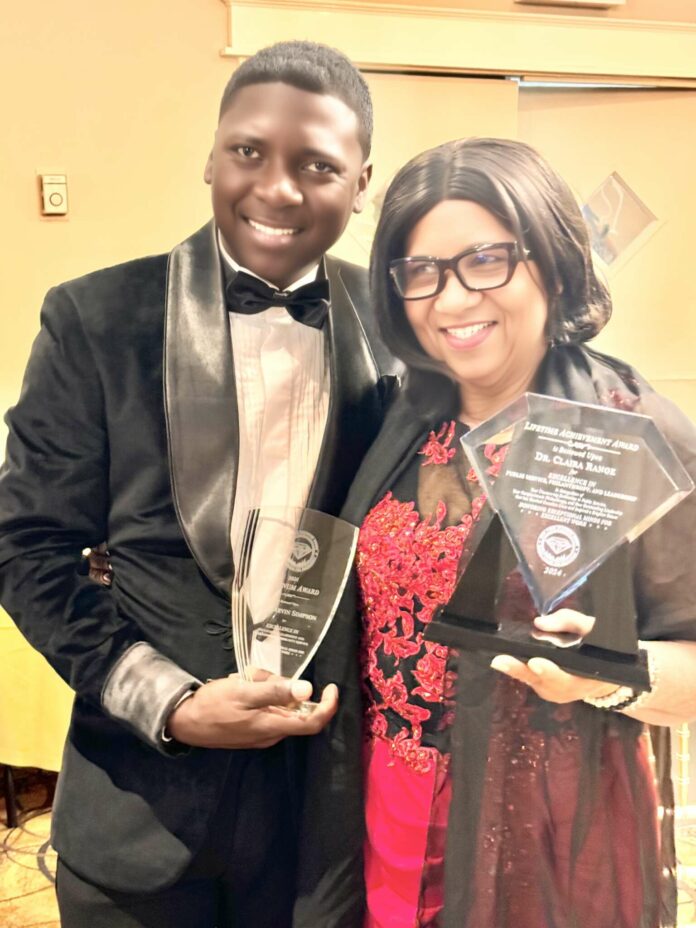 Dr. Claira Range showing off her Global Life Time Award for services to Government and Community with Dr. Marvin Simpson with his Global Award for Excellence in Educational Leadership.