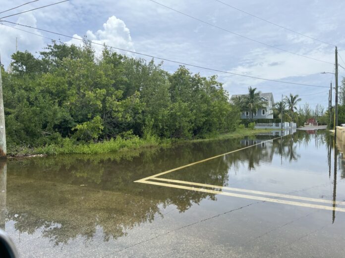 Sea water from king tides fills the road in North Sound Estates.