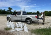 Sandbags at the ready as rain threatens to soak saturated ground truck being loaded with sandbags to prevent flooding from rain
