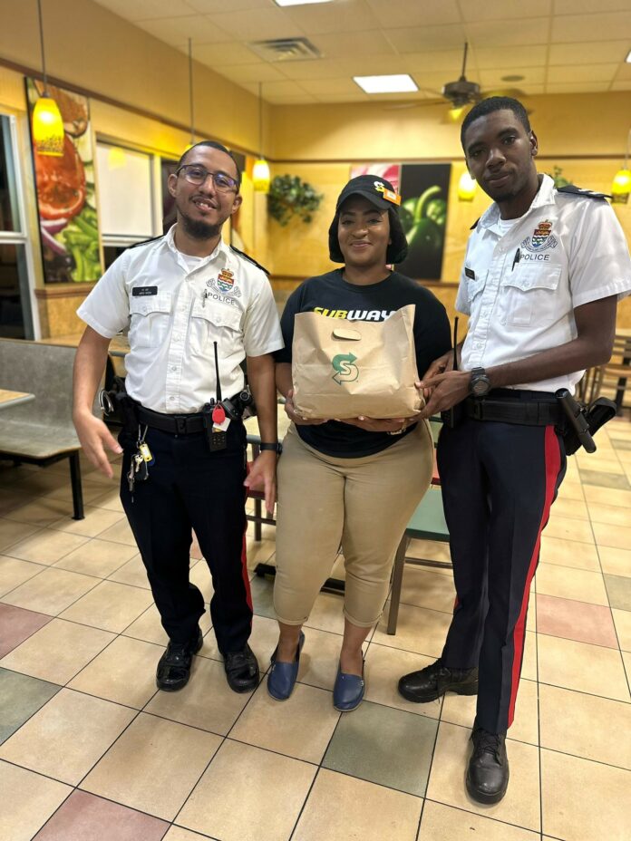 Subway employee delivering sandwiches to member of the Royal Cayman Islands Police Service