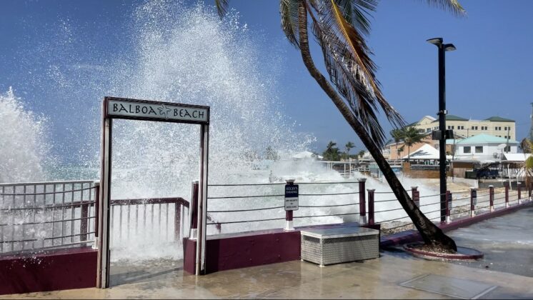 Waves crash over the Balboa Beach sign in George Town.