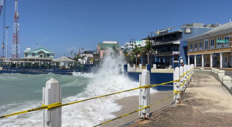 Waves crash over the waterfront in George Town.