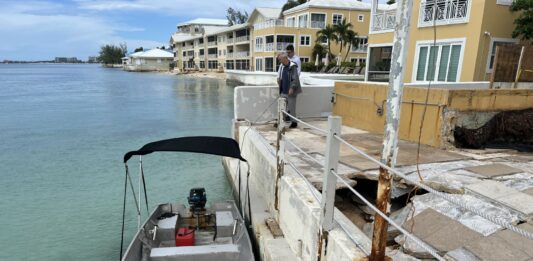 A Compass boat moored up next to the Marriott deck, where the previously pristine beach front is now under several feet of water. - Photo: Simon Boxall