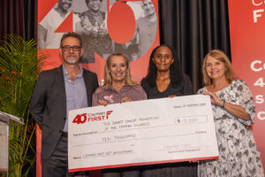 (ii)The Breast Cancer Foundation of the Cayman Islands Chief Administrator, Ms. Beverly Edgington, accepts the fourth and final “40 for 40” donation from the Cayman First Executive Team (L-R: Mr. Chris Hind, Chief Executive Officer; Ms. Edgington; Ms. Ruth Kibe, Chief Financial Officer; and Ms. Polly Pickels, Vice President – Group Insurance Services). 