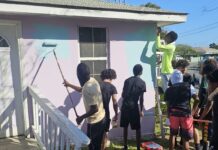 Boyz2Men paint and repair house to give back to the community Boyz2Men members work on a house in West Bay. - Photo: Supplied