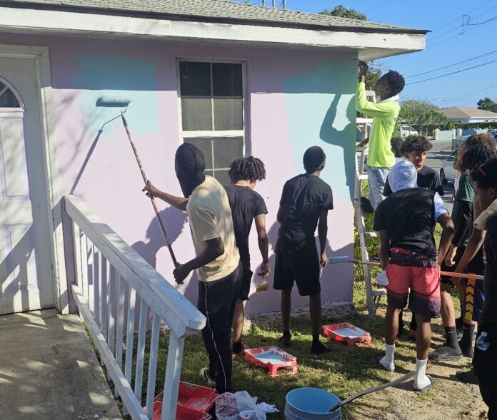 Boyz2Men members work on a house in West Bay. - Photo: Supplied