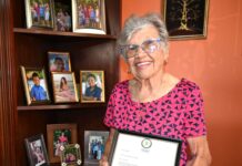 Cayman’s only living national hero passes away, aged 97 Francine A. Jackson, standing next to her display of photos of her grandchildren at her West Bay home, shows her letter affirming her status as Cayman's new National Hero. - Photo: Reshma Ragoonath