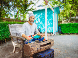 Local artist turns discarded tree into work of musical art Randy Chollette plays a drum he hollowed out of a salvaged community tree. - Photo: Taneos Ramsay