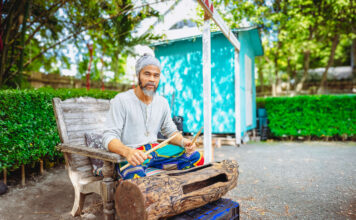 Local artist turns discarded tree into work of musical art Randy Chollette plays a drum he hollowed out of a salvaged community tree. - Photo: Taneos Ramsay