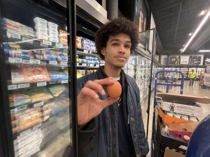 Jamaul Barnes holds up an egg at the Foster's Supermarket at Camana Bay - Photo: Simon Boxall