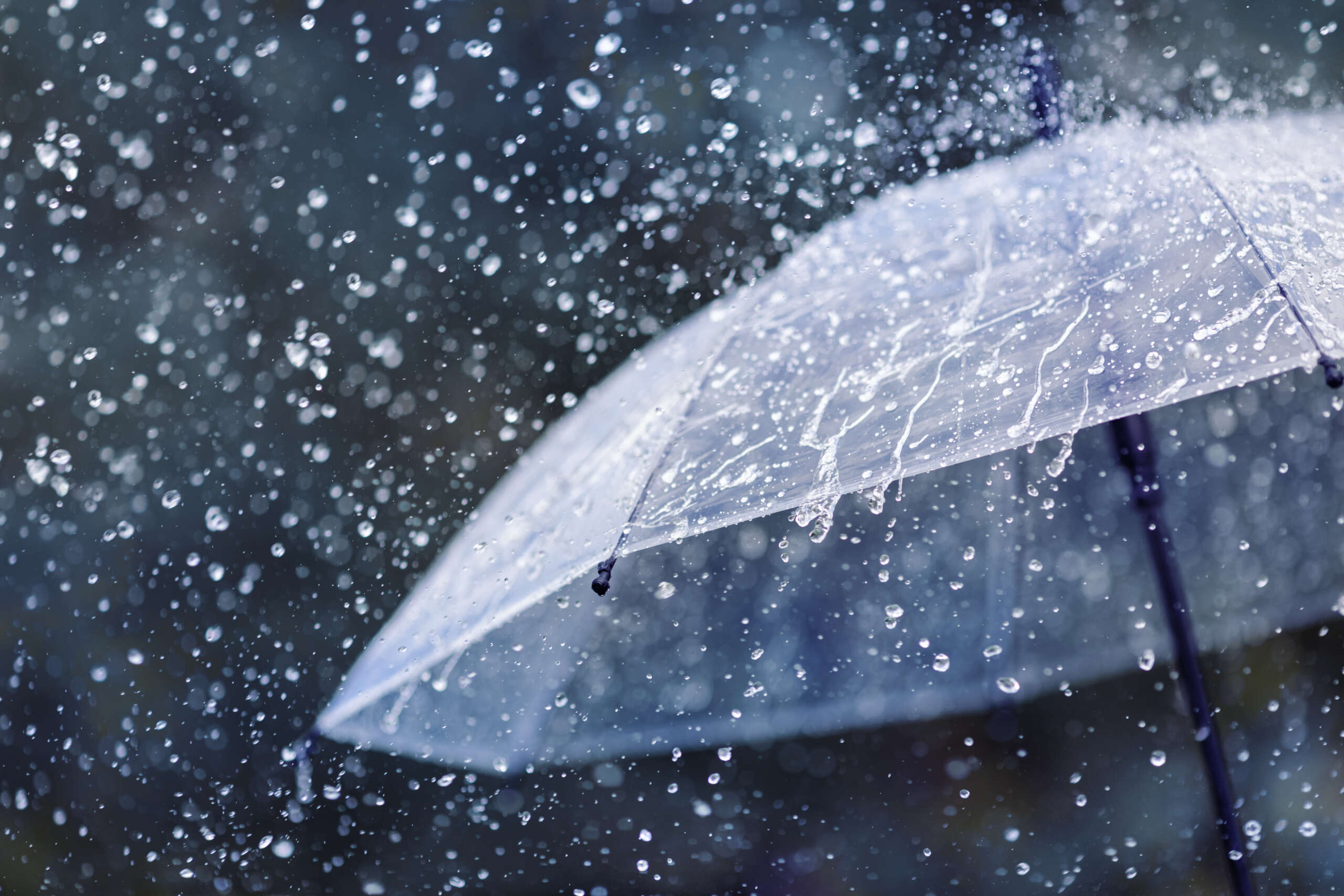 Transparent umbrella under heavy rain against water drops splash Transparent umbrella under heavy rain against water drops splash background. Rainy weather concept.