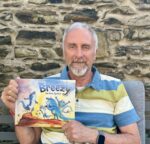 Author of ‘Breezy the Blue Iguana’ calls for responsible pet ownership Author David Roth poses with his children's book, Breezy the Blue Iguana, inspired by a real Grand Cayman iguana. - Photo: Supplied