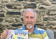 Author of ‘Breezy the Blue Iguana’ calls for responsible pet ownership Author David Roth poses with his children's book, Breezy the Blue Iguana, inspired by a real Grand Cayman iguana. - Photo: Supplied