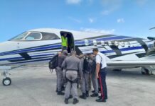 Cayman police deployed to Anguilla amid rising gang violence Cayman police officers having a word of prayer for protection before boarding the plane for Anguilla. - Photo: Supplied