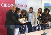CIBC relaunches ‘Unsung Heroes’ initiative across the Caribbean CIBC executives and managers look at the coffee table book 'Unsung Heroes of the Caribbean', featuring past winners of the bank’s Unsung Heroes programme. - Photo: Supplied