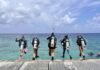 Divers get set for Women’s Dive Day on 18 July Divers jump into the water off the pier at Lighthouse Point in West Bay for Women's Dive Day. - Photo: Lisa Collins, Cayman Capture Ltd.