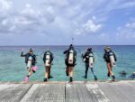 In photos: Women’s Dive Day Divers jump into the water off the pier at Lighthouse Point in West Bay for Women's Dive Day. - Photo: Lisa Collins, Cayman Capture Ltd.