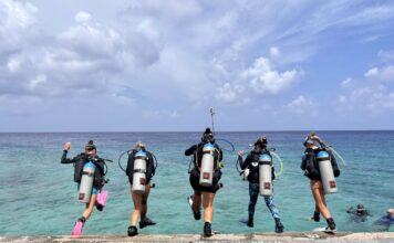 Divers get set for Women’s Dive Day on 18 July Divers jump into the water off the pier at Lighthouse Point in West Bay for Women's Dive Day. - Photo: Lisa Collins, Cayman Capture Ltd.