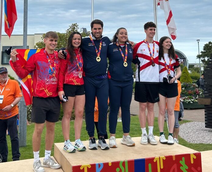Cameron Stafford and Jade Pitcairn, centre, after winning gold for Cayman in the mixed doubles squash. - Photo: Lindsey Turnbull