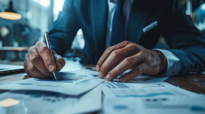 A close-up of an investment banker working on a merger and acquisition deal.