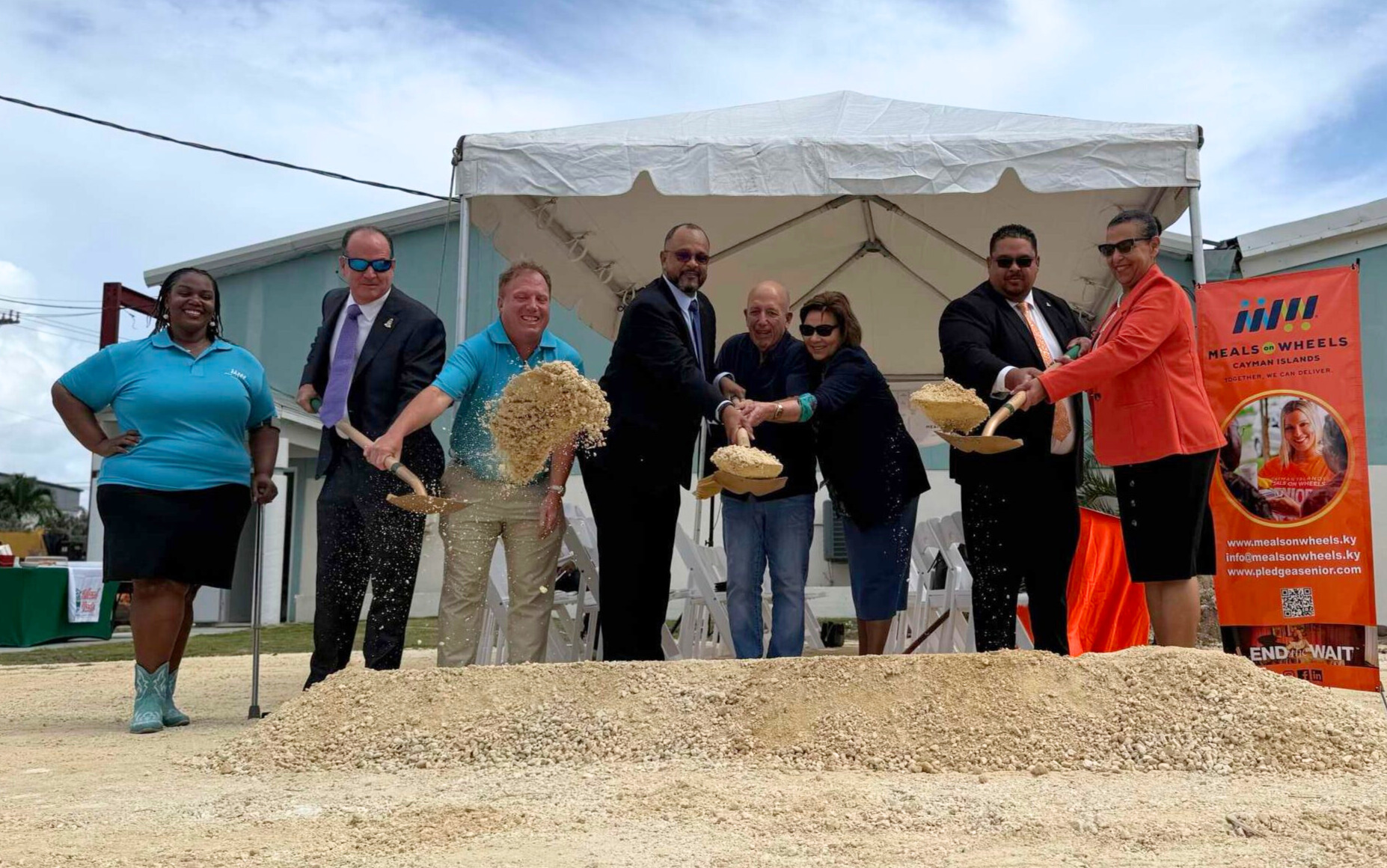 Raising the golden shovels at the Meals on Wheels groundbreaking ceremony. - Photo: Mark Westin