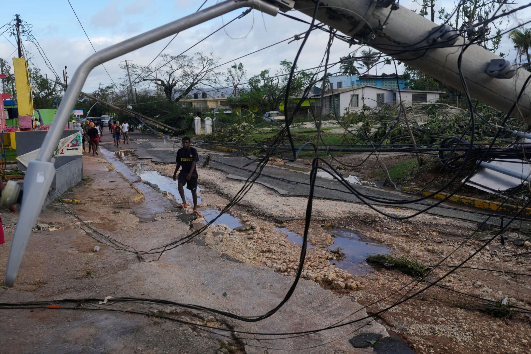 Des habitants marchent dans les rues de Santa Cruz, en Jamaïque, après le passage de l'ouragan.