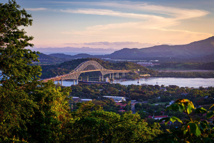 Container ship passing through Panama canal in scenic landscape